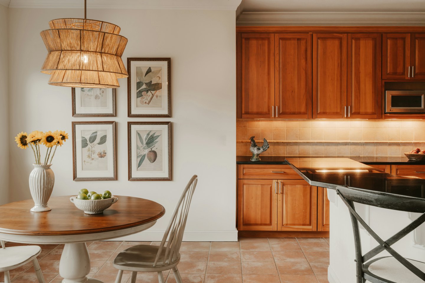 Kitchen and dining area with sunflowers on round table.
